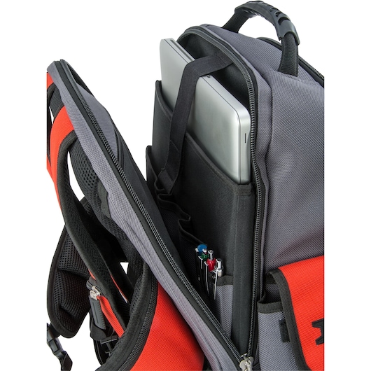Close-up image of a PROTO photography backpack with its main compartment open, showing a padded laptop sleeve holding a laptop and pockets containing several pens.