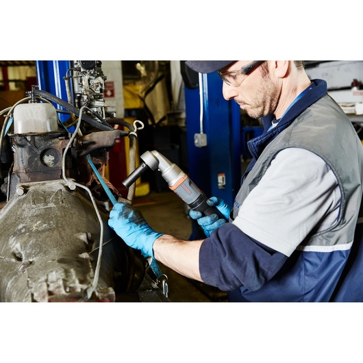 PROTO J150WA angle impact wrench in use by a technician wearing blue gloves, working on industrial machinery.