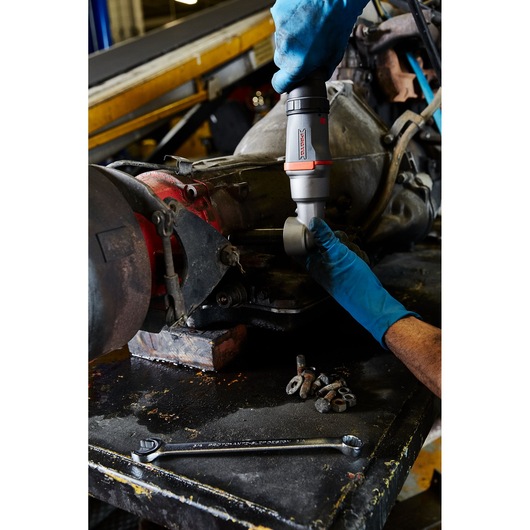 PROTO J150WA air impact wrench used by mechanic in blue gloves on engine part, wrench and bolts on workbench.