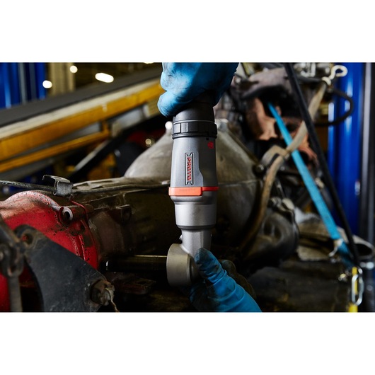 Photography of PROTO J150WA cordless ratchet used on machinery by gloved hand in workshop.