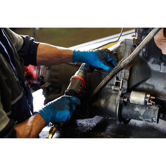 PROTO J150WA pneumatic tool being used by a mechanic with blue gloves on automotive machinery.