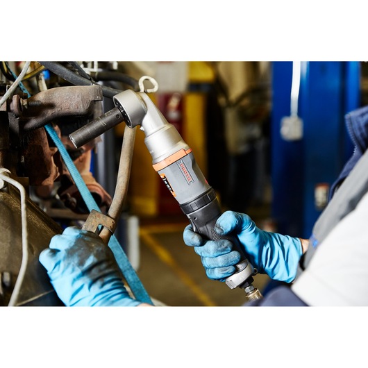 PROTO J150WA pneumatic angle grinder in use, held by gloved hands, working on automotive machinery in a workshop.