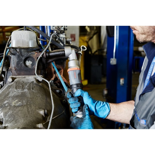 PROTOR J150WA angle impact wrench used by a mechanic with blue gloves on machinery in an industrial workshop.