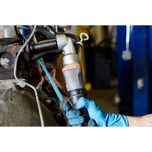 PROTO J150WA ratchet wrench in use, held by a gloved hand while tightening a bolt on industrial machinery.