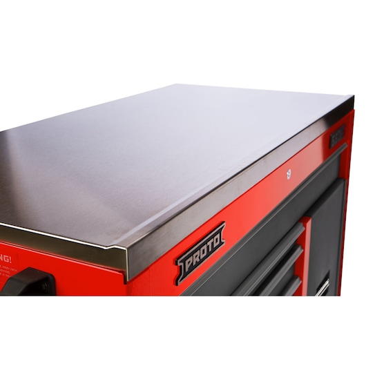Close-up view of a PROTO branded red tool chest with a stainless steel top and black drawers.