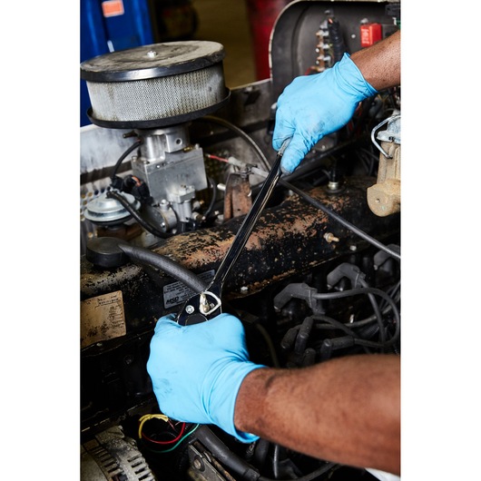 PROTO J5450 wrench used by person with blue gloves on car engine, close-up photography.
