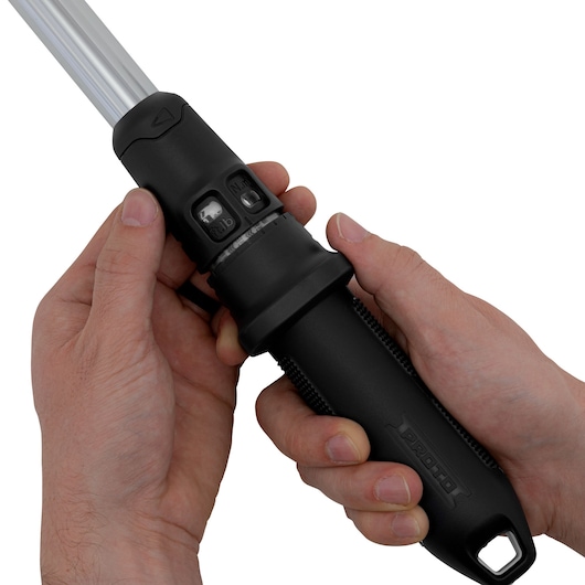 Close-up of two hands holding a black PROTO torque wrench, showing its ergonomic handle and adjustment controls.